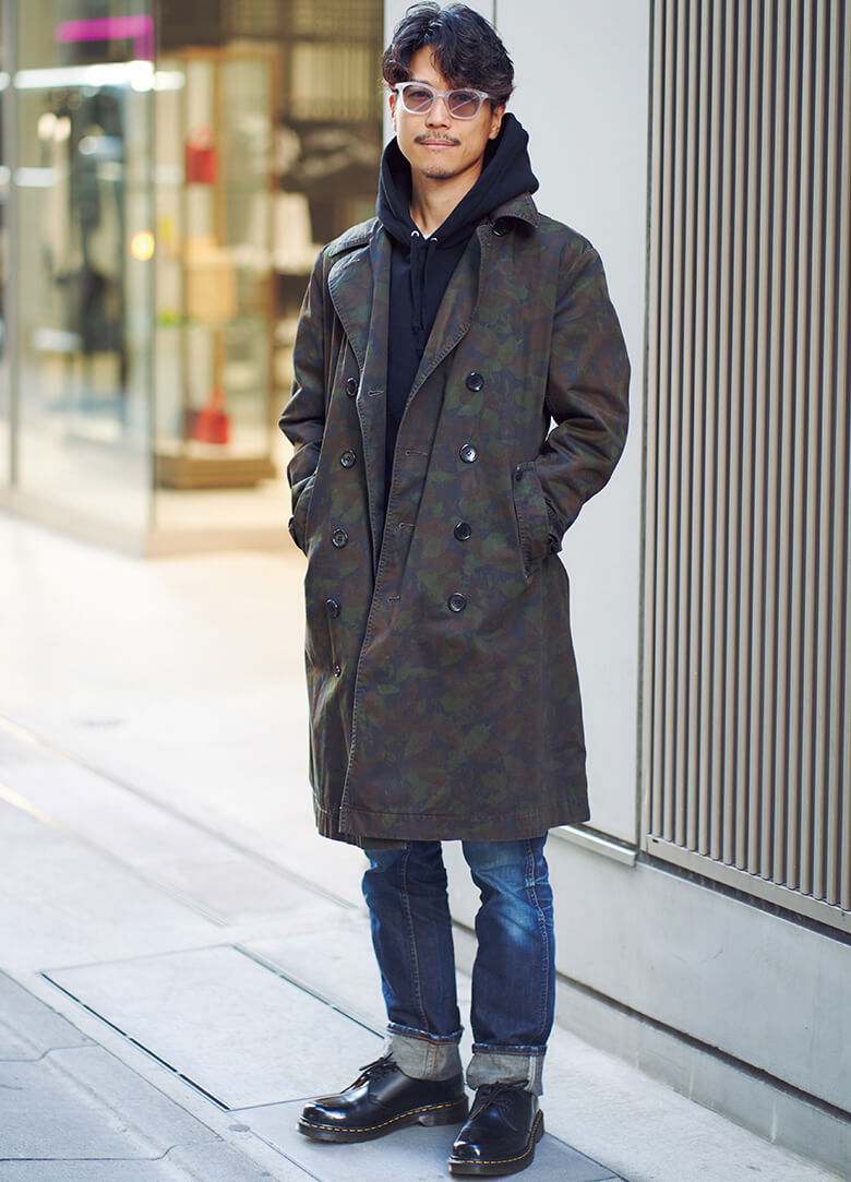 少し個性的な迷彩柄のトレンチコートも、黒のフードを覗かせるだけで、安心感のあるコーディネイトに見えるから不思議。