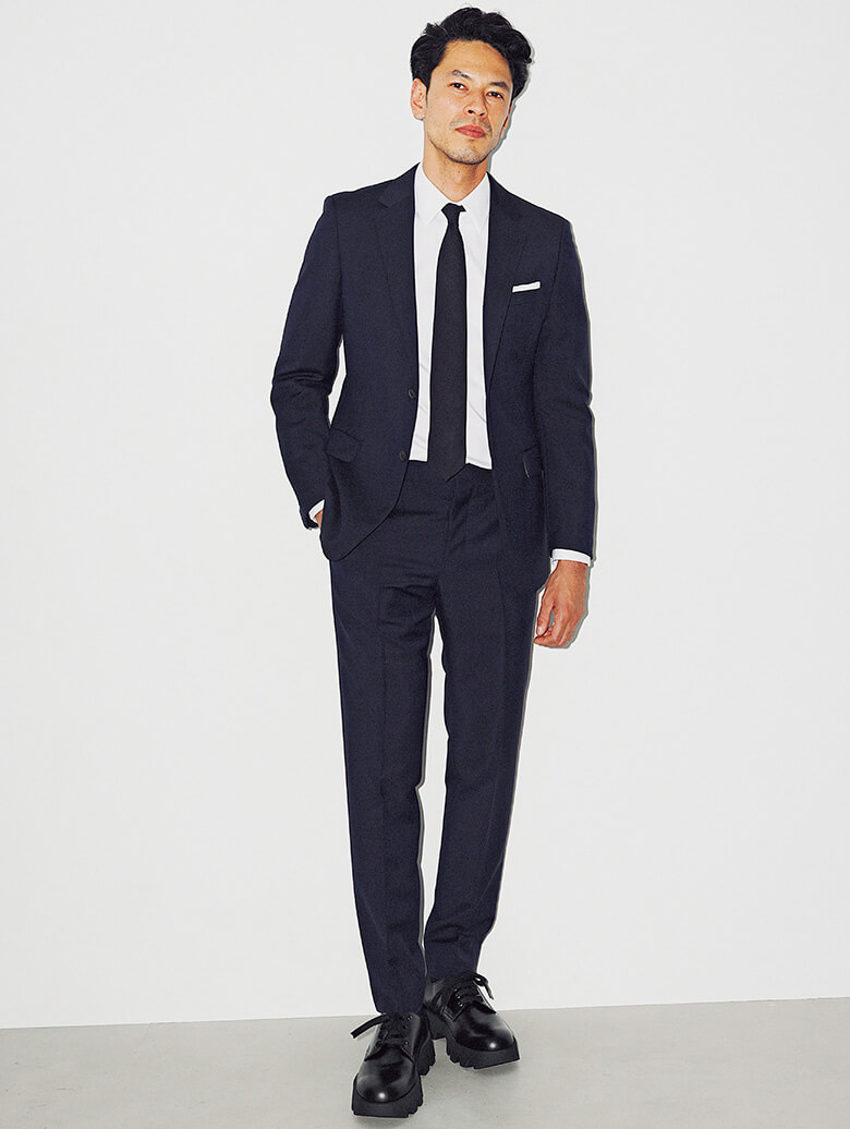 構築的なシルエットが、体の凹凸を強調してグラマラスに見せてくれるプラダのネイビースーツ。／プラダ