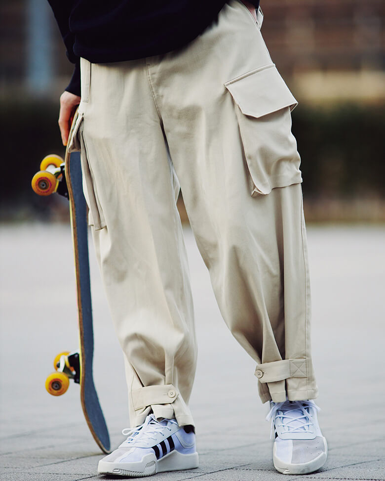 ストレッチのウールブレンド素材を太めに仕上げたパンツは、裾をボタン付きのタブで留めるアジャスターを付属。結果、テーパードシルエットも楽しめる。