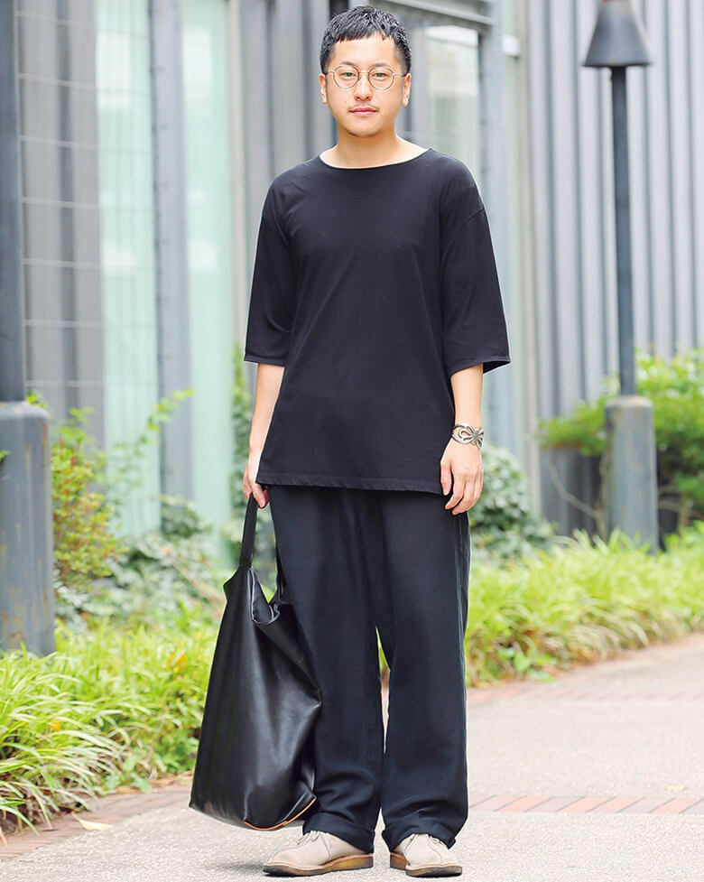 ドロップショルダーの7分丈Tシャツと、ドレープの豊かなワイドパンツでユルさを強調。それをダークトーンでまとめてモードに着地させてみせた。