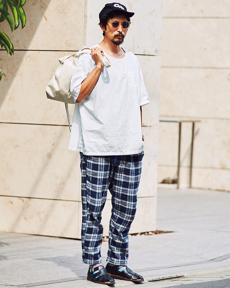 秋冬に続きチェックの流行はこの夏も。パンツの個性に合わせ、クリアフレームサングラス、グルカサンダルと主張のあるアイテムでバランスを。