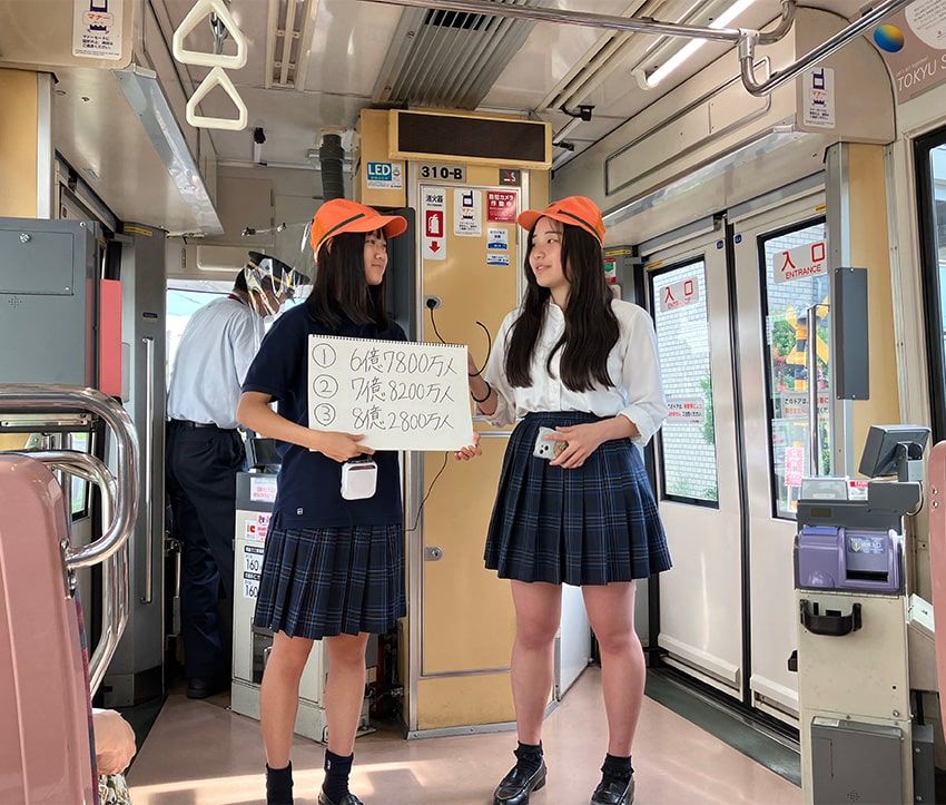 貸し切られた世田谷線「SDGsトレイン」車内で、SDGsに関わるクイズを出題する青稜中学高等学校「SDGs部」の生徒たち