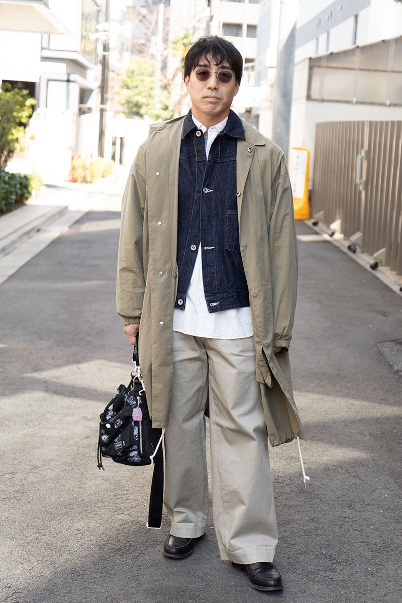 コート＝オーラリー　Gジャン、シャツ＝ともにコモリ　パンツ＝トラディショナルウェザーウェア　シューズ＝リーガル　眼鏡＝アイヴァン　バッグ＝ドラえもん×ポーター　腕時計＝アップル
