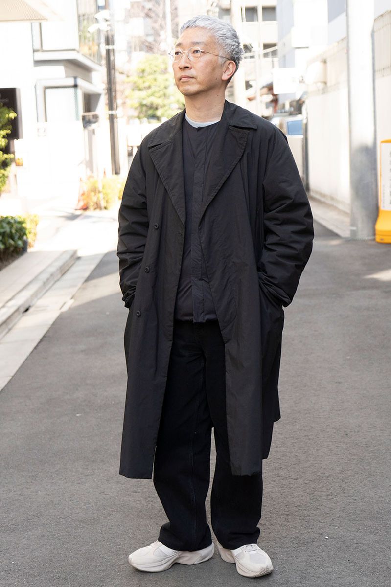 コート＝テアトラ　インナーダウン＝ナンガ×アーバンリサーチ　スウェット＝ノーブランド　デニム＝ユニクロ　シューズ＝ニューバランス　眼鏡＝ユウイチトヤマ