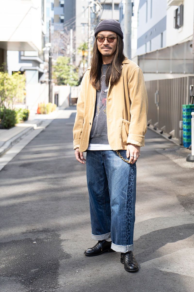 ジャケット＝ナイジェルケーボン　スウェット＝レミレリーフ　 Tシャツ＝チャンピオン　デニム、ブレスレット＝ともにブルーナボイン　シューズ＝ブラザーブリッジ　帽子＝ノーブランド　眼鏡＝モスコット　腕時計＝ロレックス　リング＝サンシャインリーブス　リング2＝スタンレイパーカー　リング3＝ビリーブインミラクル