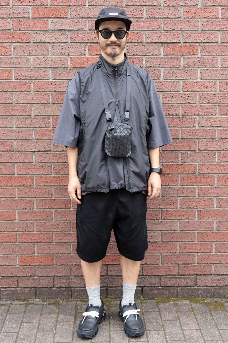 ベスト=ゴールドウイン Tシャツ、ショーツ=ともにフレッシュサービス スニーカー=ミズノ キャップ=ビームス × ネットフリックス 眼鏡=アヤメ バッグ=バオバオイッセイミヤケ 腕時計=アップル