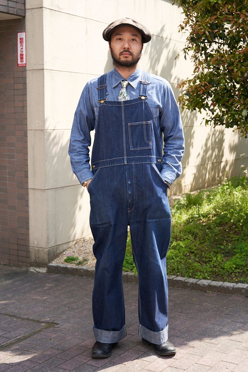 シャツ、オーバーオール＝ともにアットラスト　シューズ＝タカヒロミヤシタザソロイスト．　帽子＝ザファットハッター　腕時計＝ロレックス　ピアス＝不明　ネクタイ＝ヴィンテージ　ウォレットチェーン、ブレスレット＝ともにクロムハーツ　リング＝テンダーロイン