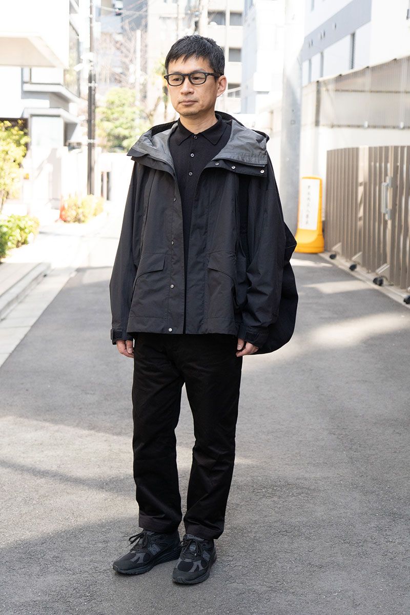 ジャケット＝ゴールドウイン×キャプテンサンシャイン　ポロシャツ＝コモリ　パンツ＝ジュンヤワタナベ　シューズ＝ドーバーストリートマーケットギン×ニューバランス　眼鏡＝アイヴァン　バッグ＝アーツアンドサイエンス　腕時計＝オメガ　リング＝カルティエ