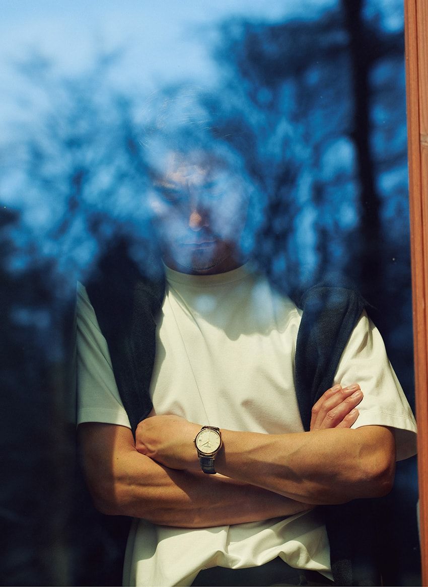 腕時計 イエローゴールドケース、39mm径、自動巻き。677万円／パテック フィリップ（パテック フィリップ ジャパン　03-3255-8109）、Tシャツ1万3200円／タンジェネット　mitsuruyoshiya@gmail.com、肩に掛けたニット3万6000円／キャッシュアンドバルバ（エグジステンス　info@cashbarba.com）