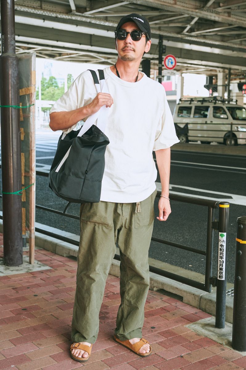 Tシャツ＝シオラヤツス　パンツ＝古着　シューズ＝ビルケンシュトック　帽子＝ゼアショップアパレル　眼鏡＝アメリカンオプティカル　バッグ＝ダブルジェイケイ　バングル、リング＝ともにヴィンテージ