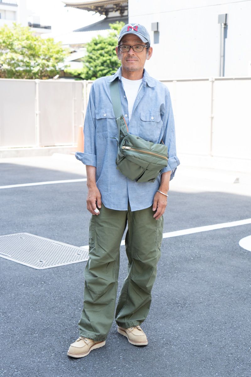 シャツ=古着 Tシャツ=ギルダン パンツ=不明 シューズ=レッドウィング 帽子=アメリカンニードル 眼鏡=泰八郎謹製 バッグ ポーター バングル=スチュードベーカーメタル