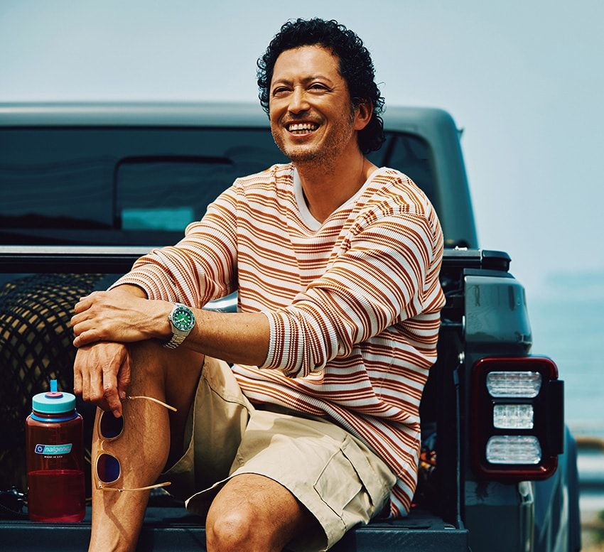 「BN0269-50W」8万1400円/シチズン 0120-78-4807、手に持ったサングラス7万3600円/ミスターライト(コンティニュエ 03-3792-8978)