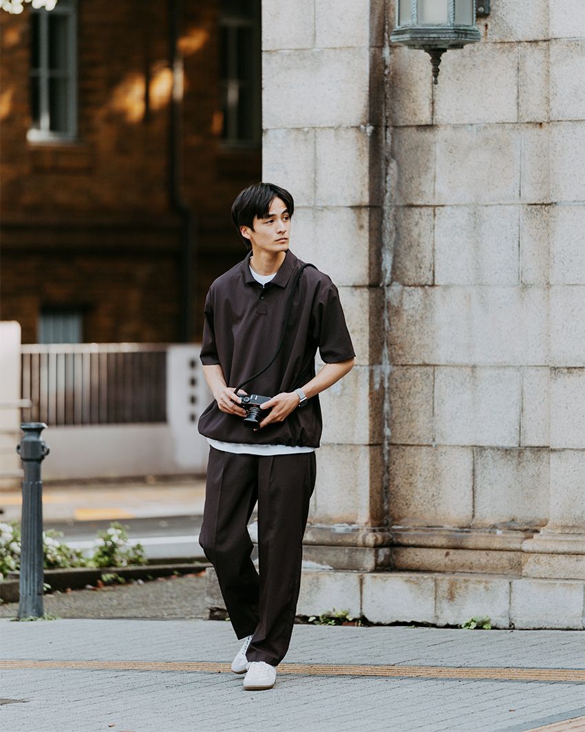 プリーツが入ったテーパードシルエットが特徴の「オルマイワイドパンツ」。トップスでボリューム感をつけ、足元にかけてすっきりさせるシルエットメイクもポイント。ポロシャツ7920円、パンツ9900円／ともにグリーンレーベル リラクシング、シューズ8690円／ジャーマントレーナー