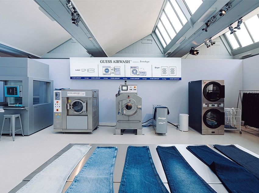 軽石で削り水で流し生まれるストーンウォッシュの風合いを、水量を大幅削減しながら実現するゲス エアウォッシュ。写真にある3つの機器によって「レーザー」「オゾン」「Eフロー」の工程は行われる。