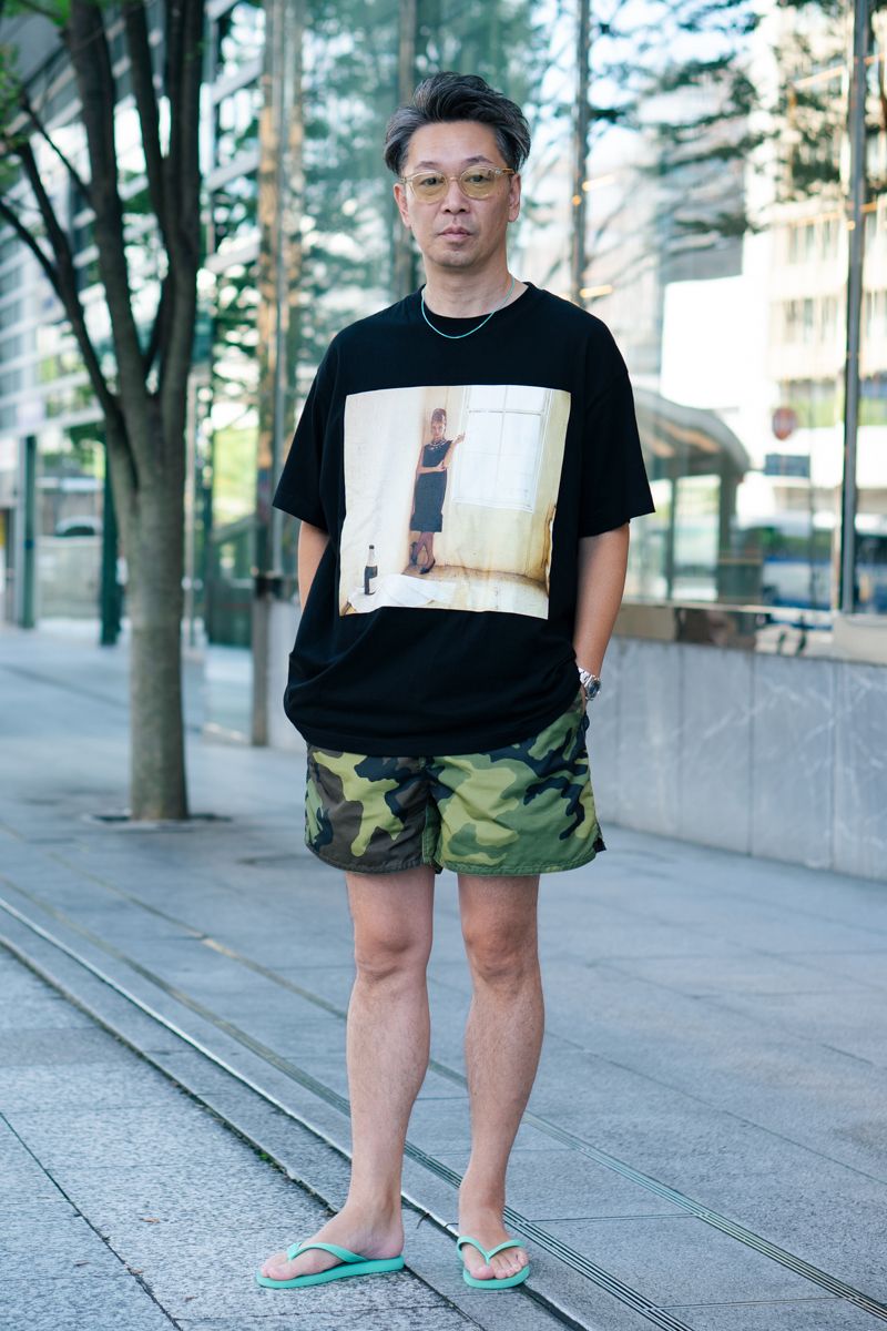 Tシャツ=アダムエロペ パンツ=バードウェル シューズ=ハワイアナス 眼鏡=アヤメ 腕時計=チューダー ネックレス、ブレスレット=ともにティファニー リング=藤井フミヤ