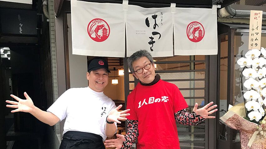 2025年3月24日、「おにぎりはつき」の1人目の客になった涌井さん。オーナーさん（左）がTシャツと趣味を面白がってくれて、開店前に写真を撮ってくれた（写真：涌井さん提供）