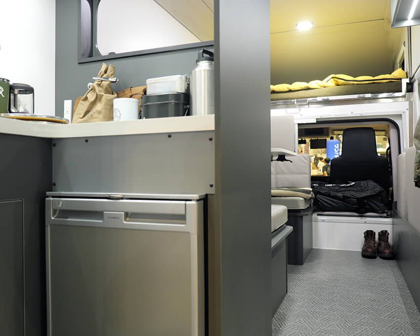 手前の入り口周りにシンクや冷蔵庫がある。その奥がソファースペース。