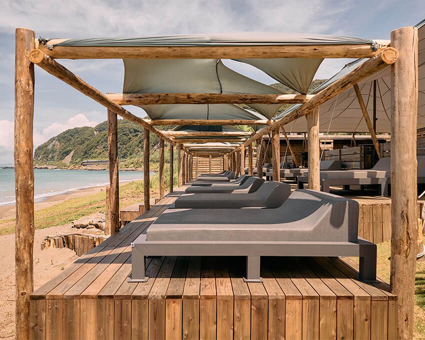 いわゆる海の家とは一線を画すデザイン性の高い空間、見た目も味もグッドなフード＆ドリンクに大満足間違いなし。入館チャージとして1名2000円（未就学児無料？）の設定。テーブル席以外に、ソファ席やビーチベッド、カバナ、ジャクジー付き個室を備え、利用する客席タイプによって別途チャージがかかる。2025年の営業は9月末日まで。以後は貸し切りパーティなど、予約ベースで限定営業を行う予定。https://motona-beachclub.botanicalpoolclub.com/