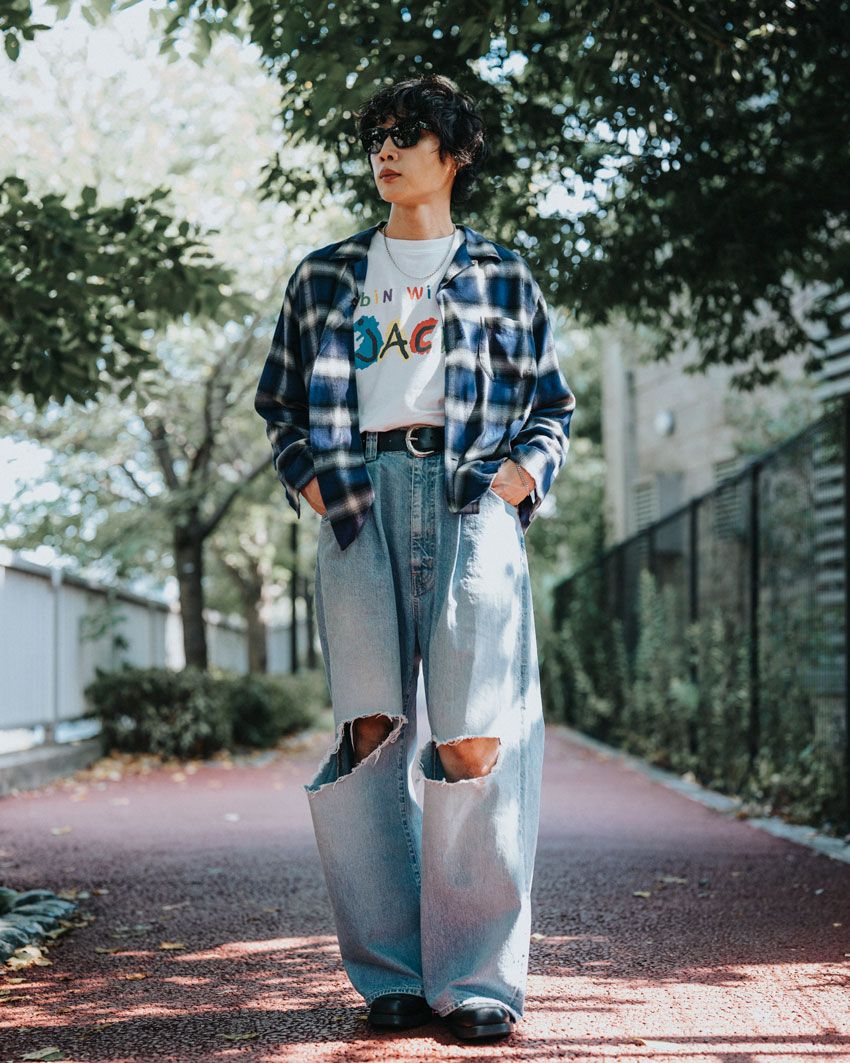 夏の午後、中目黒の街を歩く牧さんは、肩の力が抜けた白Tに、ヴィンテージライクなデニムといった装いだ。リラックスした雰囲気の奥に、フロントマンとしての確かな芯が見え隠れする。