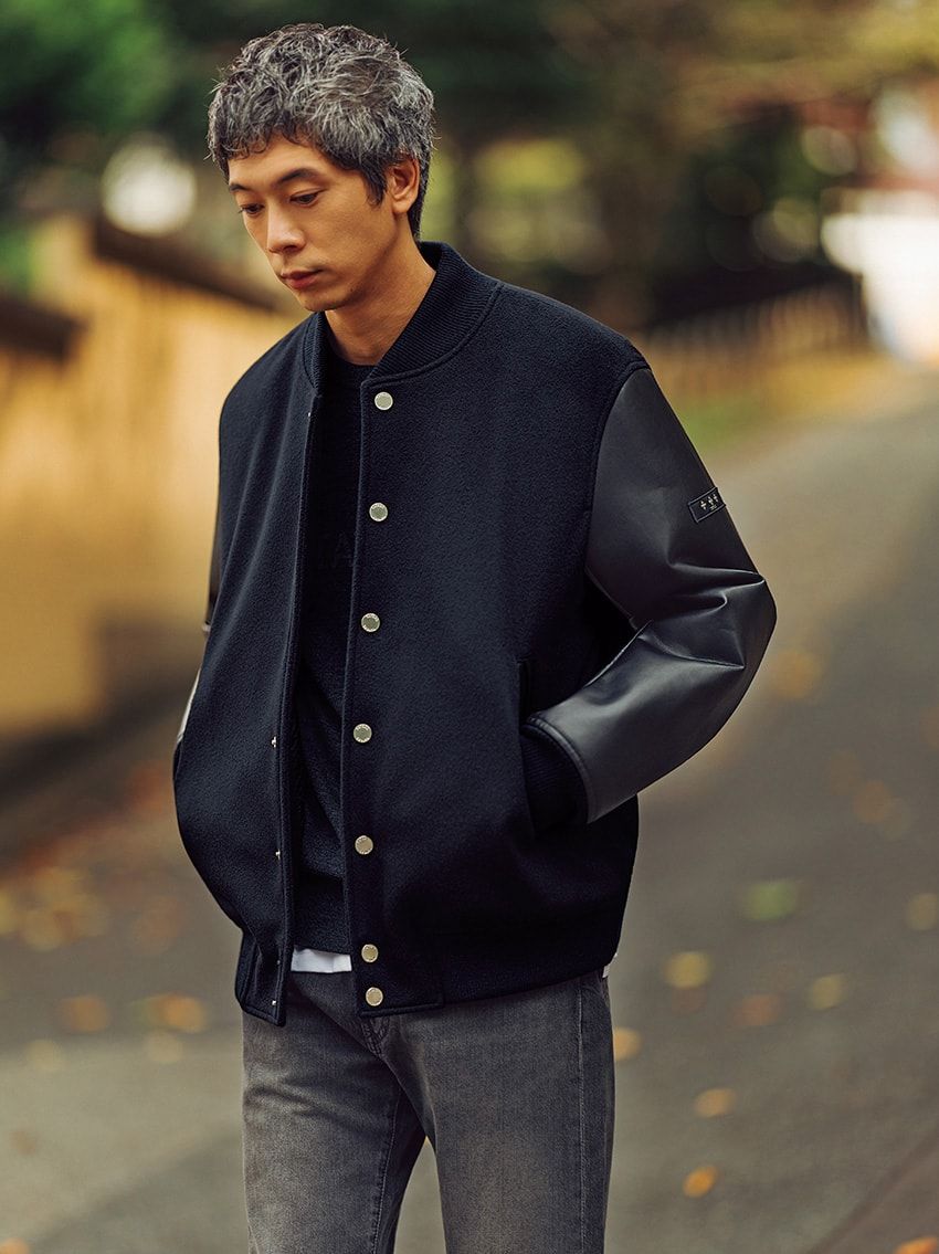 一般的なスタジャンに使われるメルトン地ではなく、ウールビーバー素材を身頃に採用した「マフィー」。起毛加工を施し、しなやかで肌触りの良い生地に仕上げている。黒のニットとブラックデニムを合わせれば、都会的な雰囲気を漂わせる“大人のアメカジ”が完成する。ダウンジャケット17万6000円、ニット5万7200円／ともにタトラス