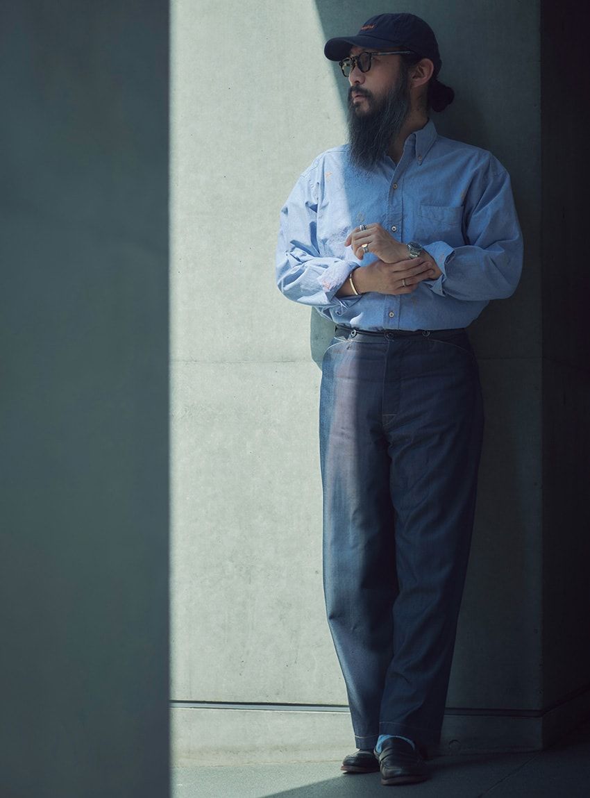 「1910年代モデル」にシャンブレーシャツという、オーセンティックな着こなしを披露してくれた大貫さん。「今回はデニムを中心に、キャップから革靴までブルーとオレンジのステッチで揃えました」とのこと。デニムはサイドシームがなくスラックスのようなシルエットで、ウール特有のドレープが実に美しい。デニム13万8000円／コールマイン ギャランティード（サンタセッ　santasse_to_2020）。シャツ＝大坪シャツ　靴＝オールデン　キャップ＝サンタセッ