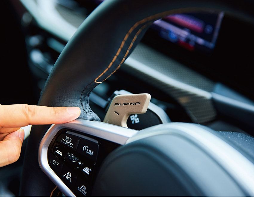 アルピナロゴを刻んだゴールド色「オロ・テクニコ」のパドルで、8速ATを優雅に、軽快に操る。「形もサイズも絶妙で、触れるたびに上質さを感じます。思わずシフトしたくなる心地良さと快音で、ついドライブが長くなる。そして、やっぱり内装は黒よりタン×ウッドの組み合わせが恋しい（笑）。そういう余裕のある色使いが“らしさ”なんです」。