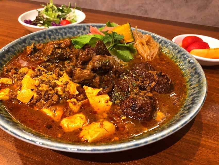 A今月のカリィ（取材時はラム肉団子）、B四川麻婆豆腐カリィ、Cラムクミン炒めカリィといった「osamu式スパイスカリィ」3種がのった「あいがけカリィ3種」1850円。