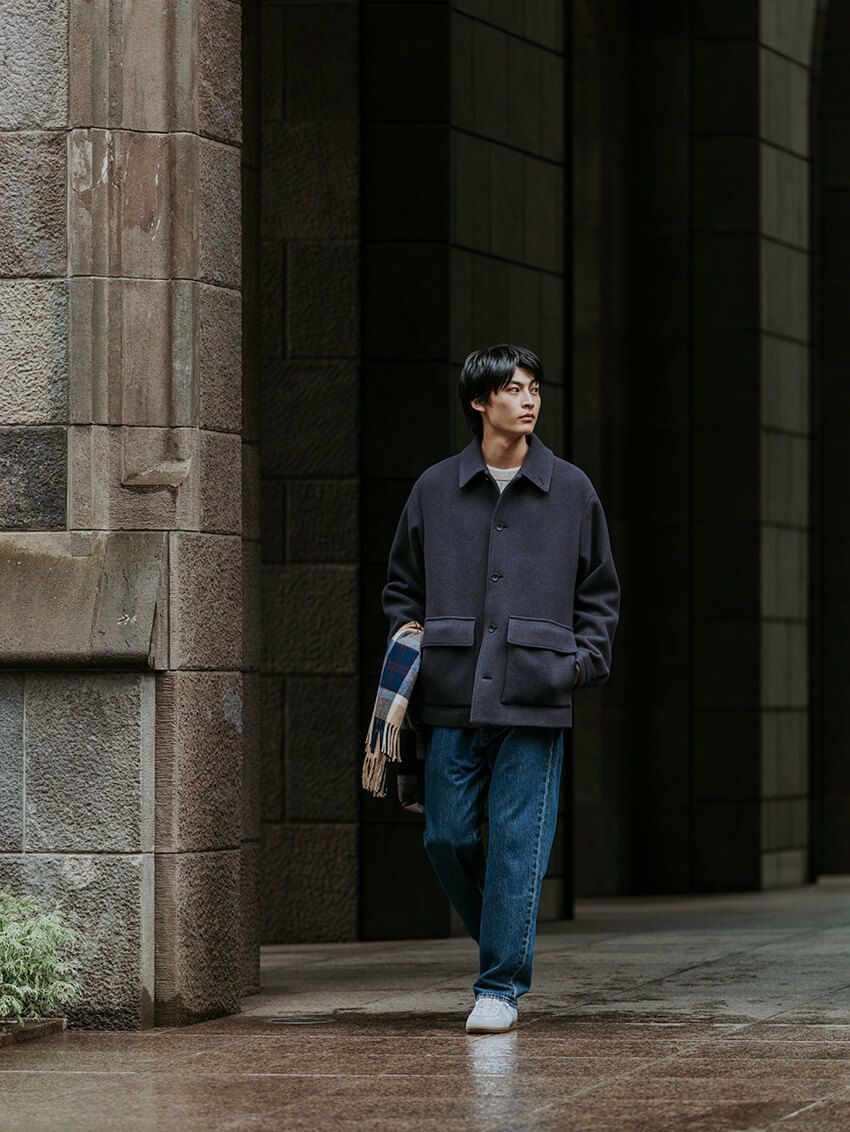 ボトムスに選んだのは、リーバイスに別注した93年モデルのストレートタイプ。カバーオールのゆったりシルエットに合わせて、やや太めのサイズをチョイスしてバランスを調整。ジャケット2万9920円、ニット1万5950円／ともにグリーンレーベル リラクシング、スニーカー8690円／ジャーマントレーナー、マフラー1万890円／ムーン、デニム1万2100円／リーバイス forグリーンレーベル リラクシング（すべてグリーンレーベル リラクシング　store.united-arrows.co.jp/brand/glr/）