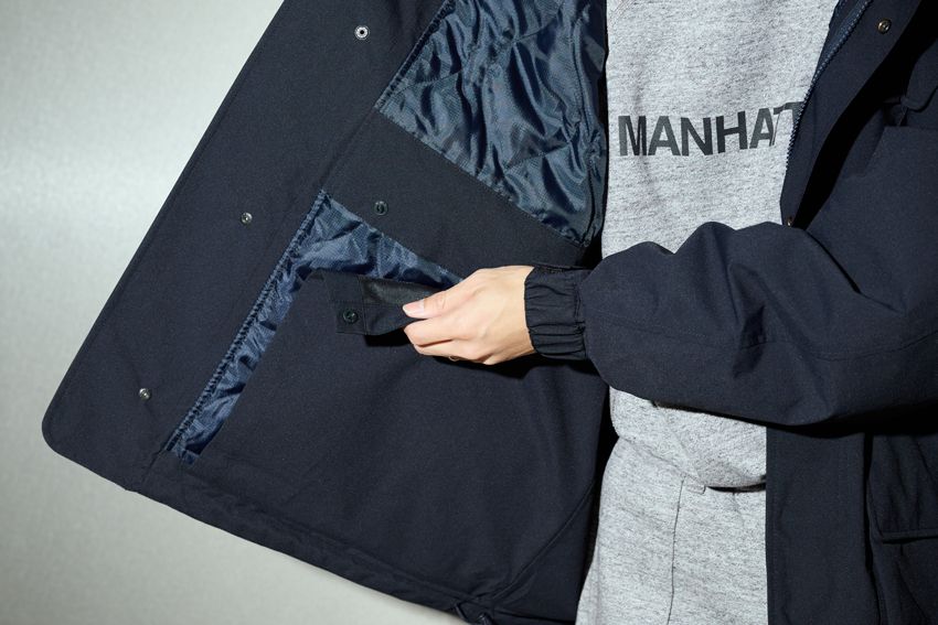 コートの内側に着丈を変えられるスナップボタンを配置。