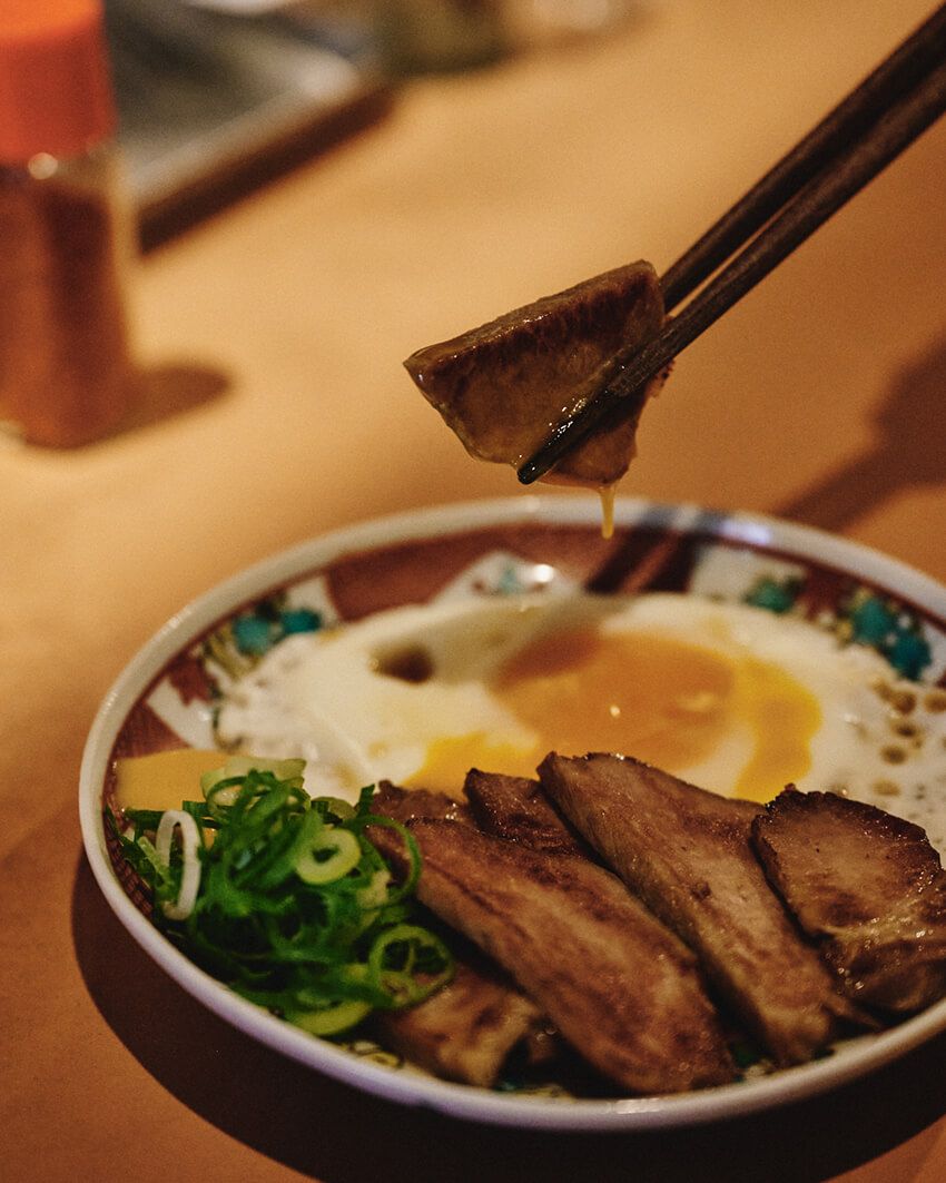 とよこやでは〈ネクタロシティ〉のハイボールをセレクト。「自家製焼豚」に目玉焼きを添えた一皿と合わせて。