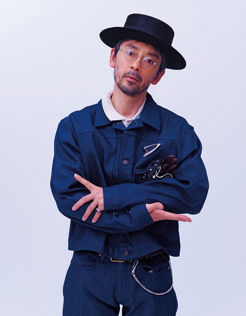 カイハラ社製のセルビッジデニムを使用したジャケットとデニムのコンビは、藍染めならではの深みのあるネイビーが上品さを際立たせている。“タイプIトラッカー”ジャケットは着丈を短めに設定しており、より軽快な雰囲気に。デニムジャケット4万9500円、ポロシャツ1万1000円、デニム3万5200円、ベルト8800円／すべてリーバイス®︎ ブルータブ™ （リーバイ•ストラウス ジャパン　0120-099-501）、ブローチ2万2880円、スカーフ1万780円／ともにトロ ヴィンテージ クロージング　03-6447-4147、グローブ3万1900円／デンツ（ 真下商事　03-6412-7081）、リング55万円／江口洋品店・江口時計店 松濤　03-5422-3070 、キーチェーン39万6000円［ 18金YGコンビ］／ニーディーズ　03-4362-8216