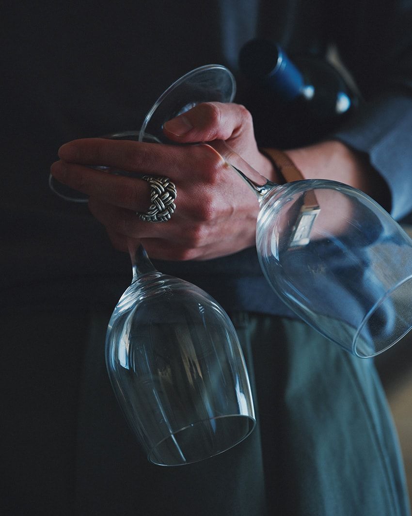 「イントレチャート リング」シルバー。14万4100円／ボッテガ・ヴェネタ（ボッテガ・ヴェネタ ジャパン　0120-60-1966）、腕時計148万7200円／ジャガー・ルクルト　0120-79-1833、ニット5万8300円／ジョン スメドレー（リーミルズ＆カンパニー　03-6277-5715）、パンツ2万6400円／トラディショナル ウェザーウェア（トラディショナル ウェザーウェア 渋谷　03-6419-7771）