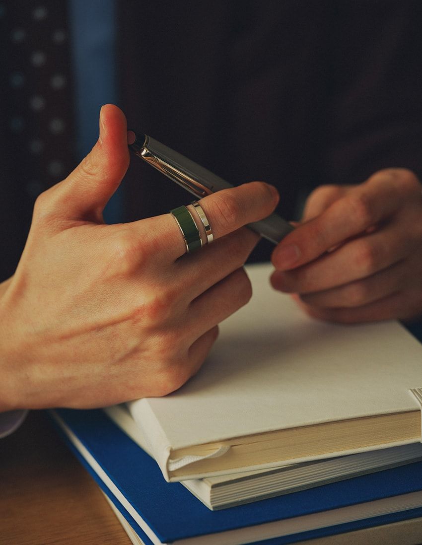 「ベルベル・クロマティック オリーブ グリーン ラッカーリング」K18WG。55万9900円〜／レポシ（レポシ日本橋三越本店　03-6262-6677）、ジャケット7万4800円／キャバン（キャバン 丸の内店　03-3286-5105）、シャツ2万7500円／トゥモローランド　0120-983-522、タイ1万8700円／ブルックス ブラザーズ（ブルックス ブラザーズ ジャパン　0120-02-1818）