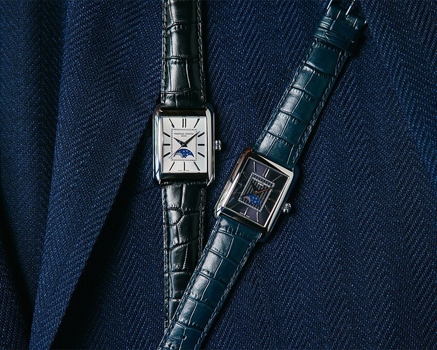 過去に何度か採用された線路型分目盛の内側に施された「シェブロンパターン」と、ムーンフェイズが共鳴。アール・デコ調の角型ケースと相まって、独自のエレガンスを見せてくれる。右がミッドナイトブルー、左がホワイトのダイヤル。「クラシック カレ ムーンフェイズ オートマチック」SSケース、ケースサイズ縦33.3mm×横30.4mm、自動巻き。各33万円／フレデリック・コンスタント　0570-03-1988