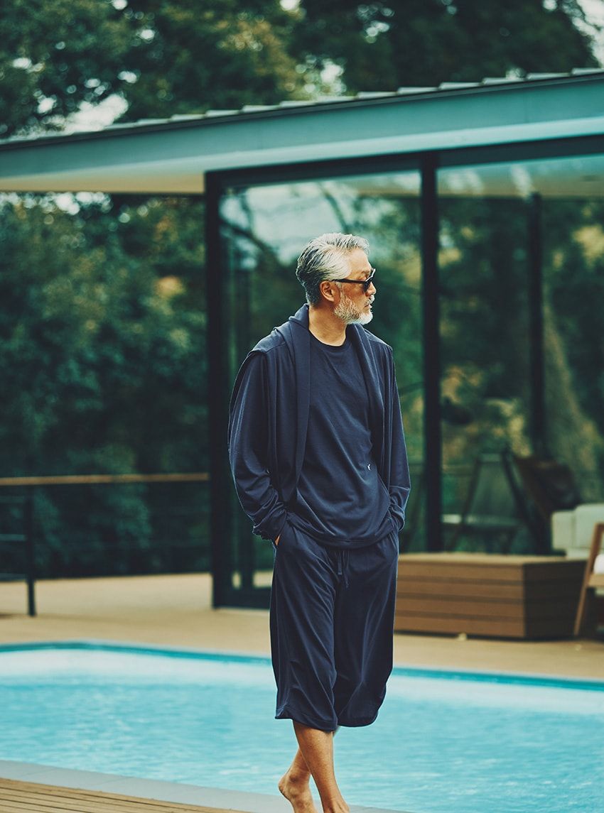 スウェットライクなデザインを取り入れたラグラン袖のカットソーにクロップドパンツを合わせたスタイリング。ウール混の生地らしい落ち感と気品溢れる表情により、上品な大人の雰囲気が漂っている。クルーネック3万800円、クロップドパンツ3万800円、肩に掛けたフーディー3万3000円／すべてベネクス フォー ウールラボ（ベネクス　046-200-9288）