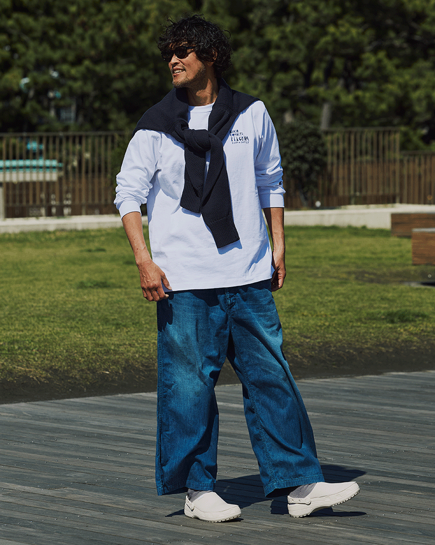 カットソー1万4850円／チャンピオン×ピルグリム サーフ+サプライ（ビームス公式オンラインショップ　www.beams.co.jp）、デニム4万9500円／ヘリル（にしのや　03-6434-0983）、肩にかけたニット6万500円／ユーゲン（イデアス　03-6869-4279）