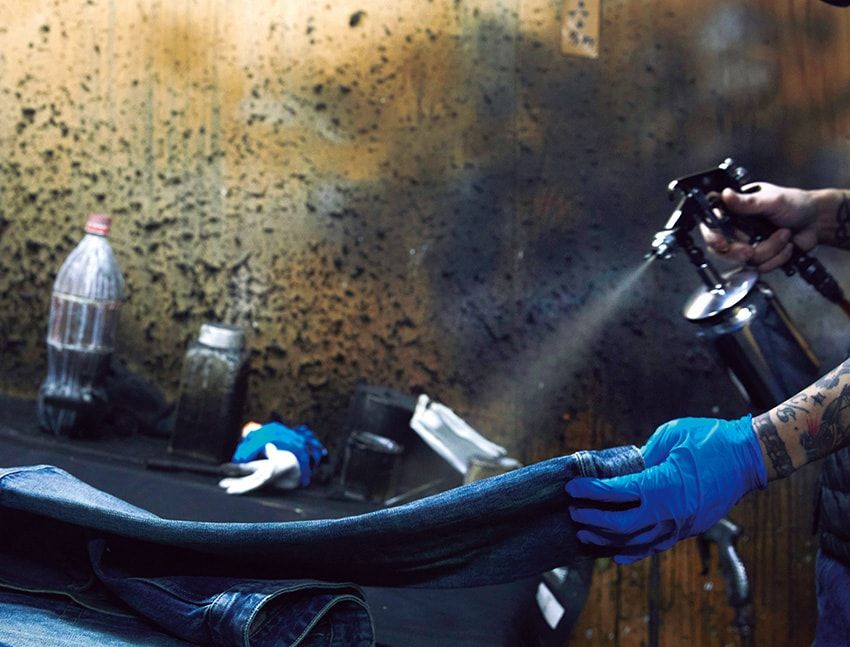 スプレーで染料や顔料を吹きつけ、エイジングを再現する「ヨゴシ」。インディゴに影響しないよう、事前に色を落とした白い部分を狙ってピンポイントで吹きつける。その量はすべて職人の目分量で決まるため、数値化は不可能。