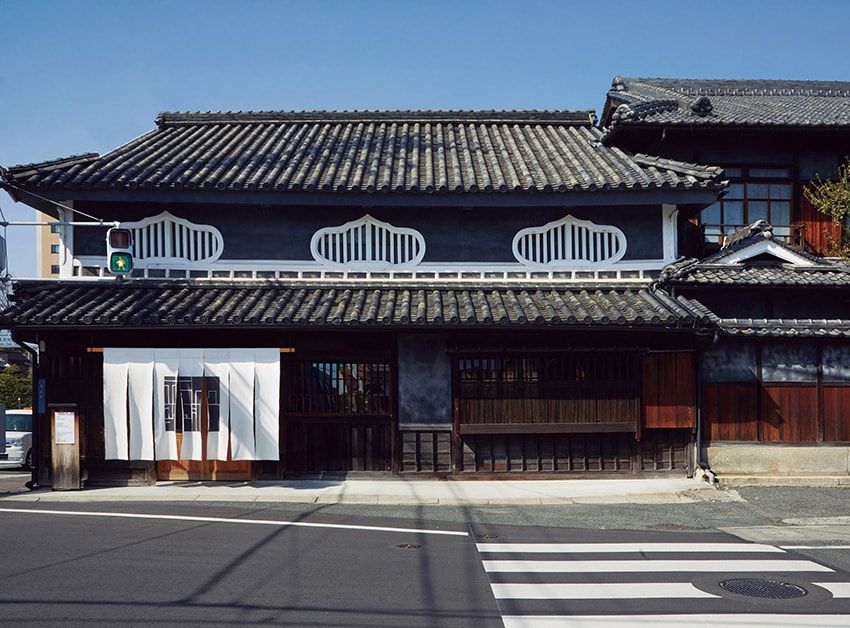 建物は、後楽園通りと旧倉敷往来の角地に立つ。もともと池田藩の依頼を受けて創業した醤油蔵で、その後は市民銀行として近隣の住民に親しまれてきた。