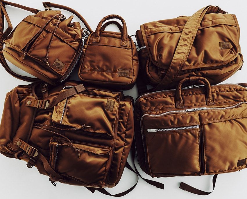 2025年に創業90周年を迎えた吉田カバン。昨年より限定アイテムが多数リリースされてきたが、今回の「タンカー コヨーテ」第2弾が、そのフィナーレを飾るアイテムとなる。全5型をラインナップし、すべてのバッグにシリアルナンバーのタグが付く。右上から時計回りに●H25×W36×D13㎝ 9万9000円、H40×W29×D9㎝ 11万円、H42×W32×D16㎝ 14万3000円、H28×W22×D13.5㎝ 7万4800円、H19×W19×D13.5㎝ 6万6000円／すべてポーター（ポーター 表参道　03-5464-1766）