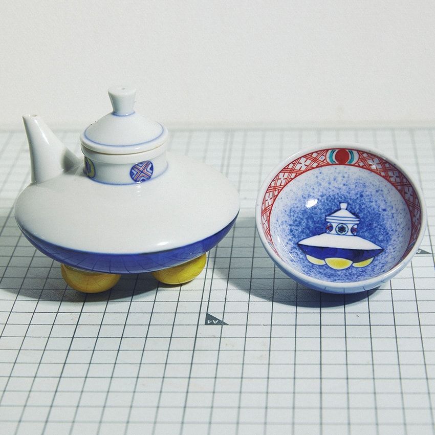 「上出長右衛門窯」の小皿、急須。「最近はとにかく、宇宙モノにハマりすぎて（笑）」と三田さん。その趣味をきっかけに縁がつながった九谷焼の窯元「上出長右衛門窯」の6代目・上出惠悟さんとは、「やっぱりUFOはアダムスキー型がいいよね」という共通認識が。「上出さんの絵心がとても好きなんです。こちらの小皿と急須のほかにもアダムスキー型の照明を作っていたりもします」。三田さんは小皿に茶菓子を入れて使用。同デザインのキーホルダーチャームも愛用している。