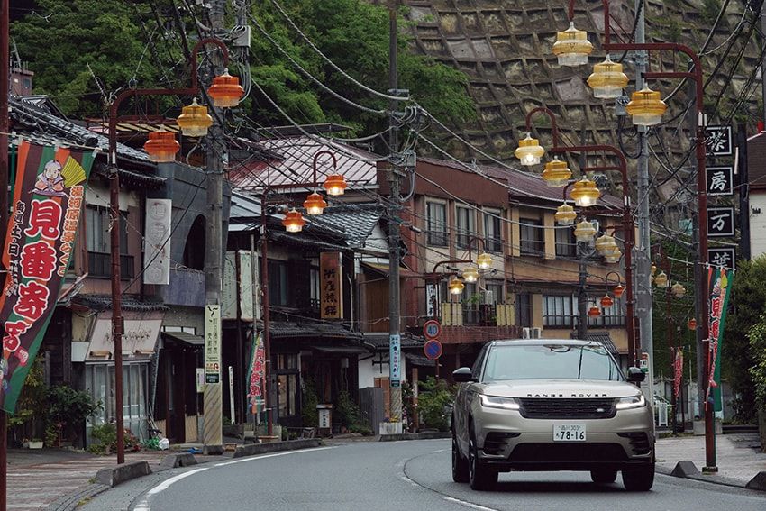 かつて文人たちが静養に訪れた湯河原の温泉街を、レンジローバー ヴェラールがゆっくりと走り抜ける。引き算の美学を極めた造形は、歴史ある町並みにすっと馴染む。その静かな空気の中、アクセルを踏むと車内はさらに静まり返る。外の気配を程良く遠ざけてくれるこの感じが心地いい。「レンジローバー ヴェラール」全長4820×全幅1930×全高1685㎜、乗車定員5名。899万円〜／レンジローバー（ランドローバーコール　0120-18-5568）