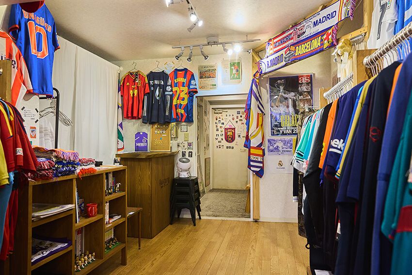 マンションの一室にひっそりと佇む、まさしく隠れ家と呼ぶに相応しいお店。店内にはヴィンテージから今季物のサッカーユニが所狭しと並ぶ。