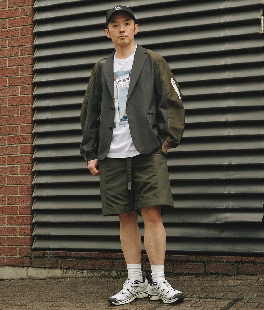 ジャケット、ショーツ＝サカイ　Tシャツ＝カラー　スニーカー＝サロモン　バッグ＝JW アンダーソン　帽子＝アンダーカバー