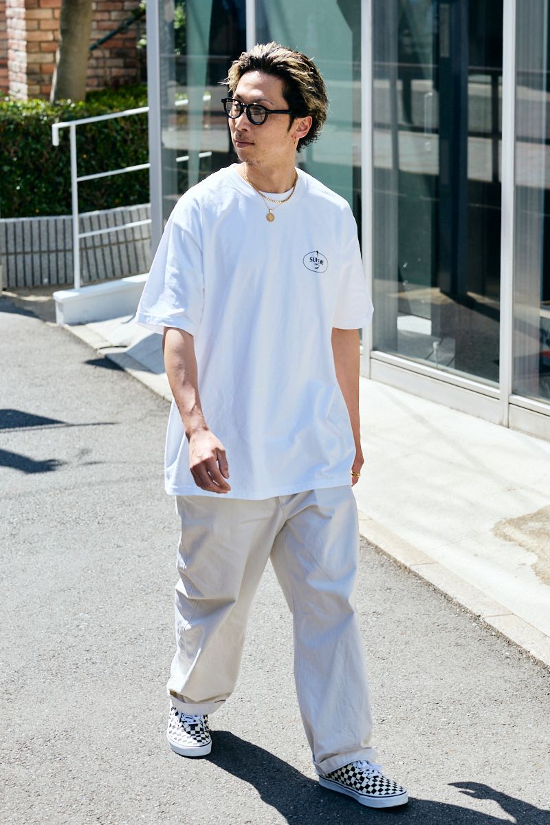 Tシャツ＝シュプリーム　パンツ、 眼鏡＝ともにユニクロ　シューズ＝ヴァンズ　ネックレス＝アヴァランチ　リング＝不明