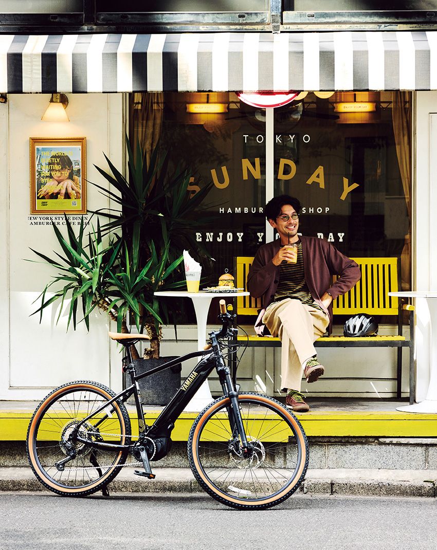 これまでなかなか足を運べなかったレストランでランチを堪能し、気になっていた古着店やレコード店をサクサクとはしごする。機動力重視で気ままに街を巡れるのも、E-bikeならではの魅力だ。ライズ付きハンドルバーのおかげでアップライトな乗車姿勢がキープでき、長時間のライドでも疲れにくいのがうれしいポイント。カーディガン1万990円／アンフィーロ（オンワード樫山　03-5476-5811）、カットソー2万7500円／フィル ザ ビル（フィル ザ ビル マーカンタイル　03-6450-3331）、パンツ3万5200円／ニート（にしのや　03-6434-0983）、サングラス6万500円／E5 アイヴァン（アイヴァン PR　03-6450-5300）、スニーカー1万7930円／ニューバランス（ニューバランスジャパン　0120-85-7120）