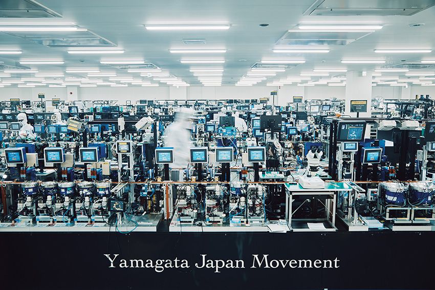 山形カシオの時計製造専用棟、G棟。工場というより、研究施設を思わせる空間で、カシオのアナログ時計のムーブメントが生産され、世界各地へと供給されている。2018年に完成したこの棟は、東日本大震災の経験をもとに免震構造を採用。守るべき技術を受け継ぎながら、それを取り巻く環境も進化させている。