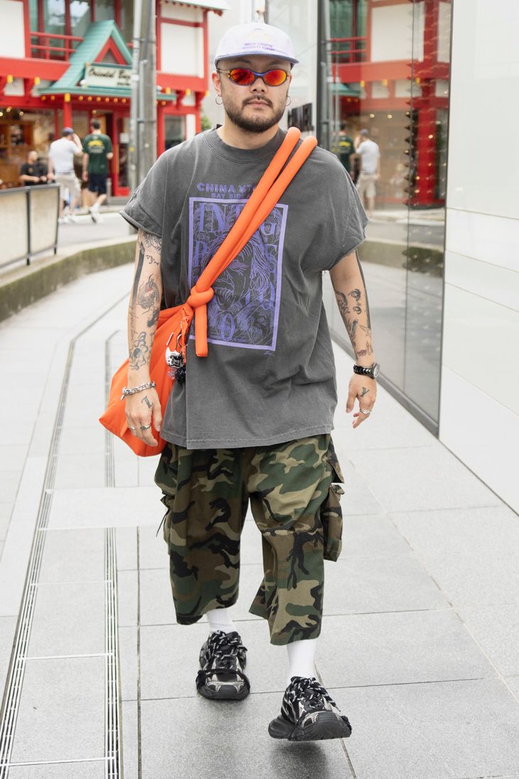 Tシャツ、ピアス、バングル、リング＝すべてノーブランド　パンツ＝リフォメッド　シューズ＝バレンシアガ　帽子＝ハローサンライズ　眼鏡、腕時計＝ともにオークリー　バッグ＝オーレンド