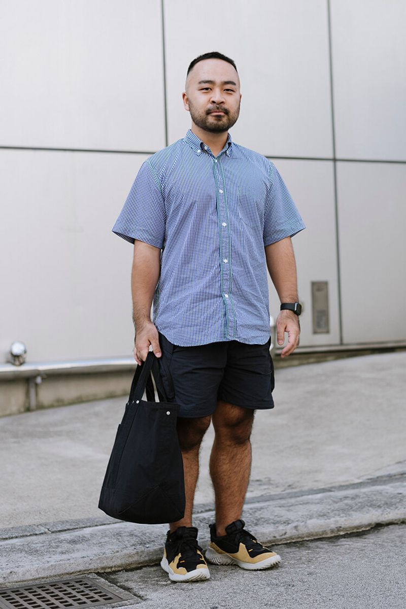 シャツのステッチを主役にする、ショーツ、バッグ、時計の黒合わせ 西野悠司