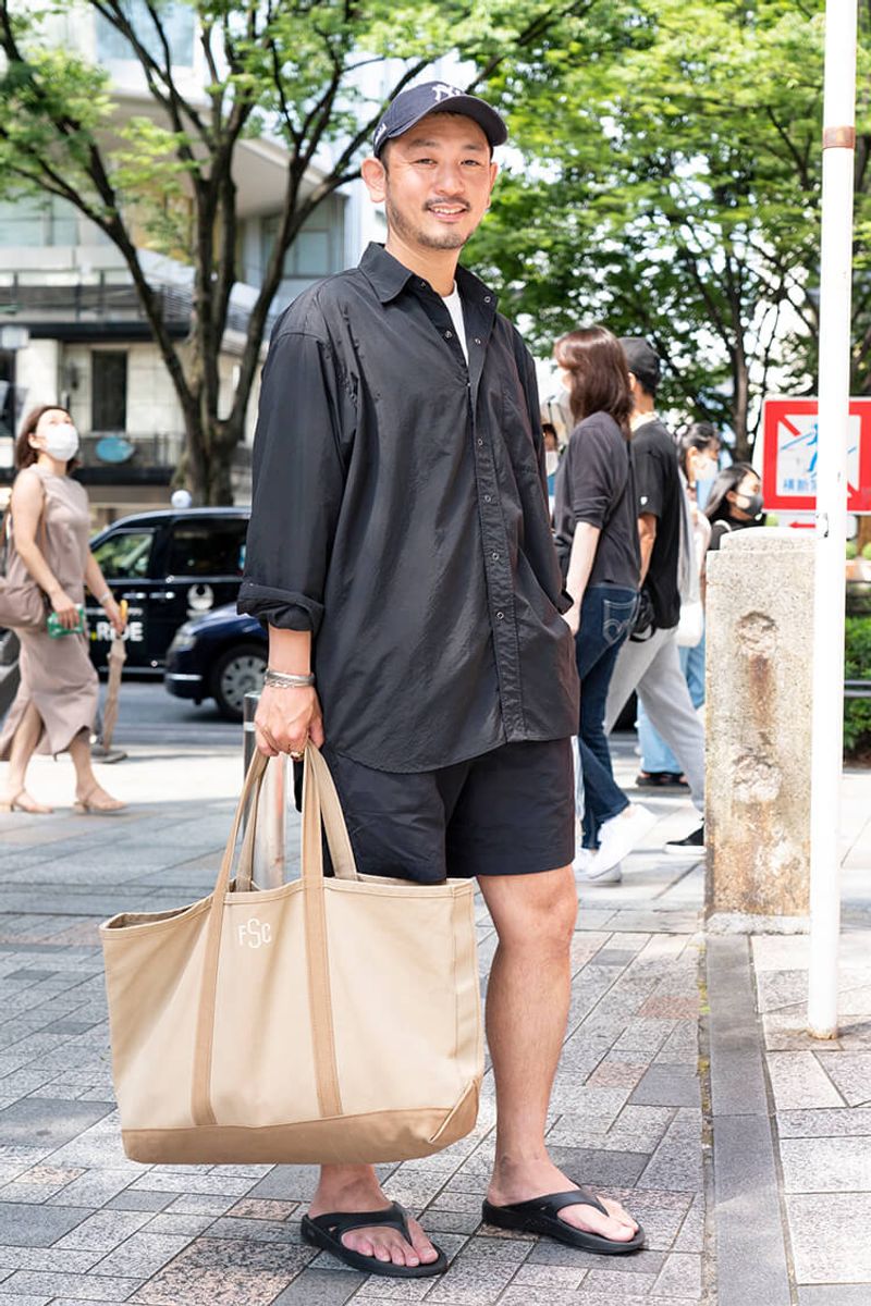 オールブラックを軽やかにキメる、ショーツ、サンダル、キャップの合わせ技 村手謙介