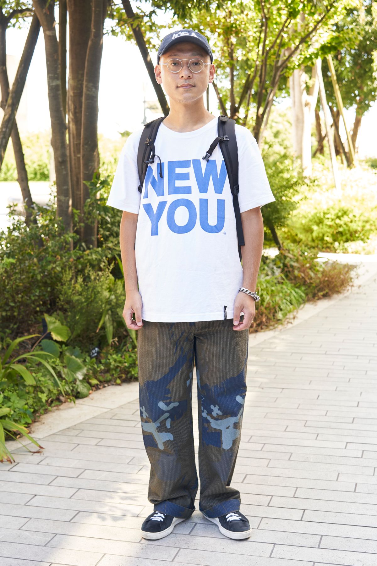 Tシャツ＝マウンテンリサーチ　パンツ＝グリフィン　シューズ＝プーマ　帽子＝アイデア　眼鏡＝アイヴァン　バッグ＝パタゴニア　ブレスレット、リング＝ともにクロムハーツ 